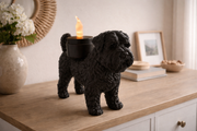 Zwarte Waxinelichthouder Bouvier des Flandres met led-waxinelichtje op houten kast in huiselijke omgeving.